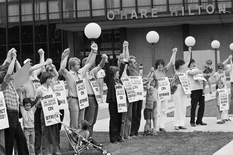 Members of PATCO hold hands and raise their arms as their deadline to return to work passes. President Reagan fired them.